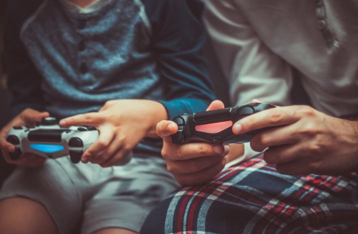 Image shows a father and son holding gaming controllers.