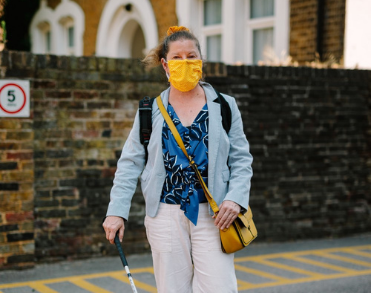 A woman with a face mask walking down the street