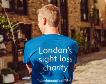 Vision Foundation staff members wearing a blue shirt which has 'London's sight loss charity' written on the back.