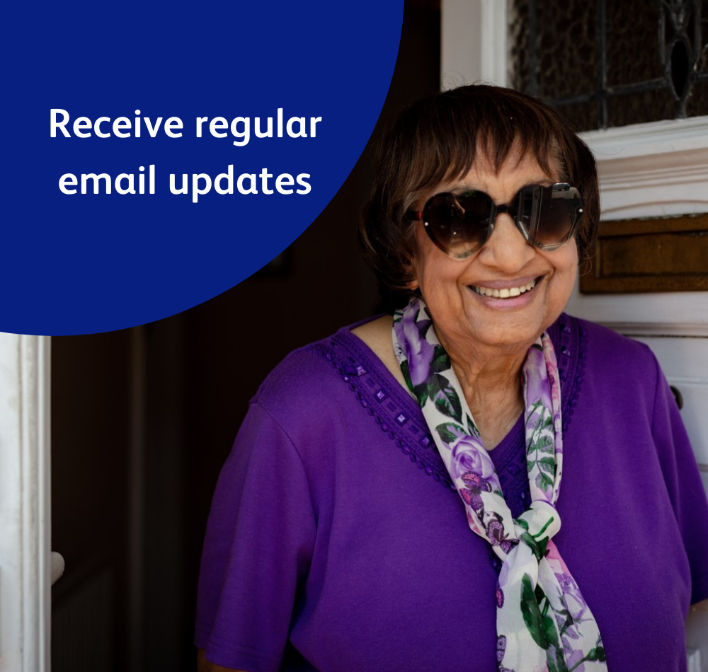 Image reads 'Receive regular email updates,' and shows a lady, Mary, who was supported by the Vision Foundation during the covid-19 crisis. Mary stands smiling on her doorstep.