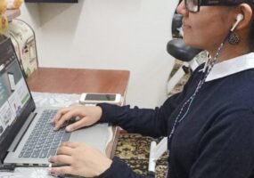 A profile photo of Rubab Rizvi using laptop at the desk