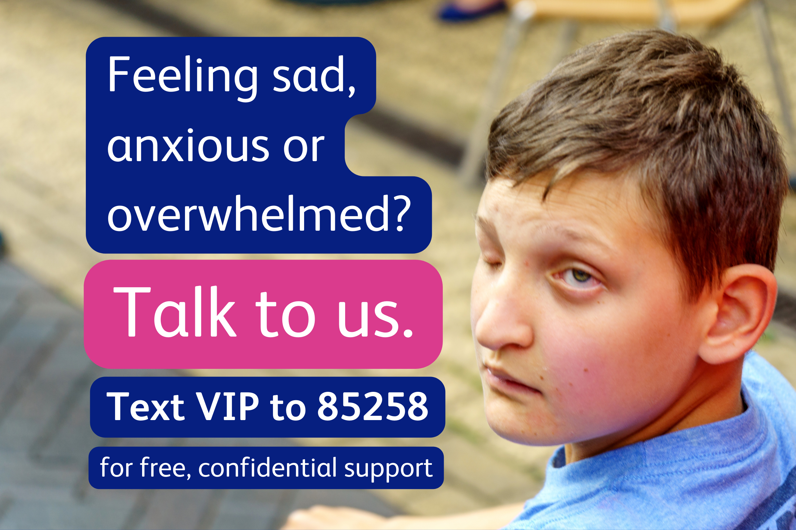 A white, visually impaired teenage boy is sitting and looking over his shoulder, facing towards the camera with a straight-faced expression. He has short, sandy brown hair. Text: “Feeling sad, anxious, or overwhelmed? Talk to us. Text VIP to 85258 for free, confidential support, 24/7.